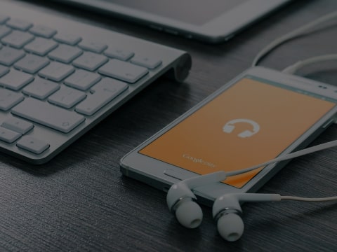 A phone and headphones are on the table.