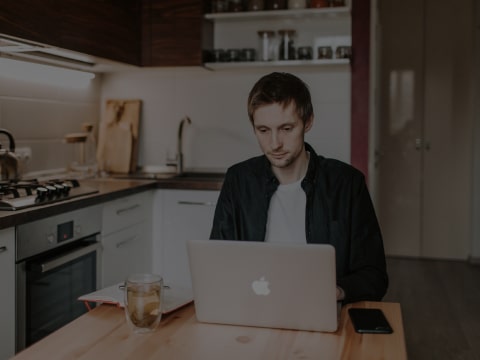 A man sitting at the table with his laptop.